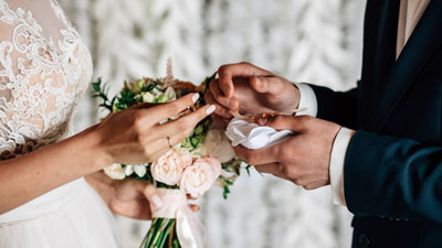 Braut zieht Braeutigam bei der Hochzeit den Ring an